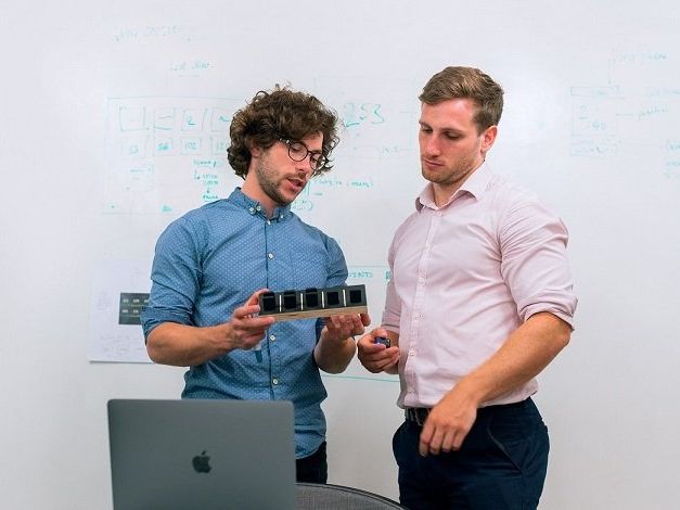 two electronics designers looking at an electronic prototype