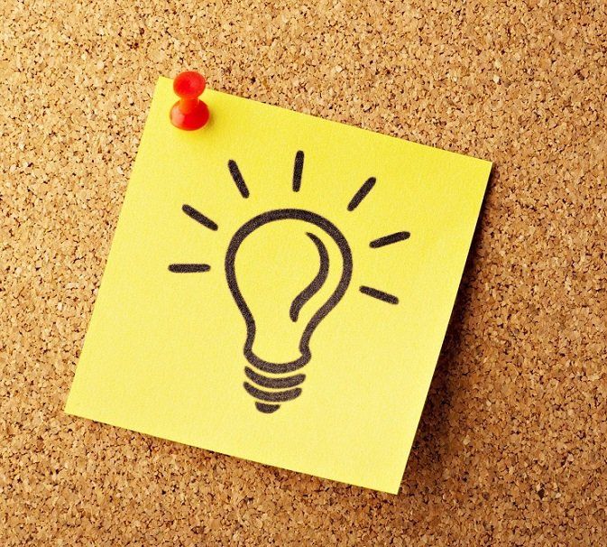 Light bulb image on post it note pinned to board