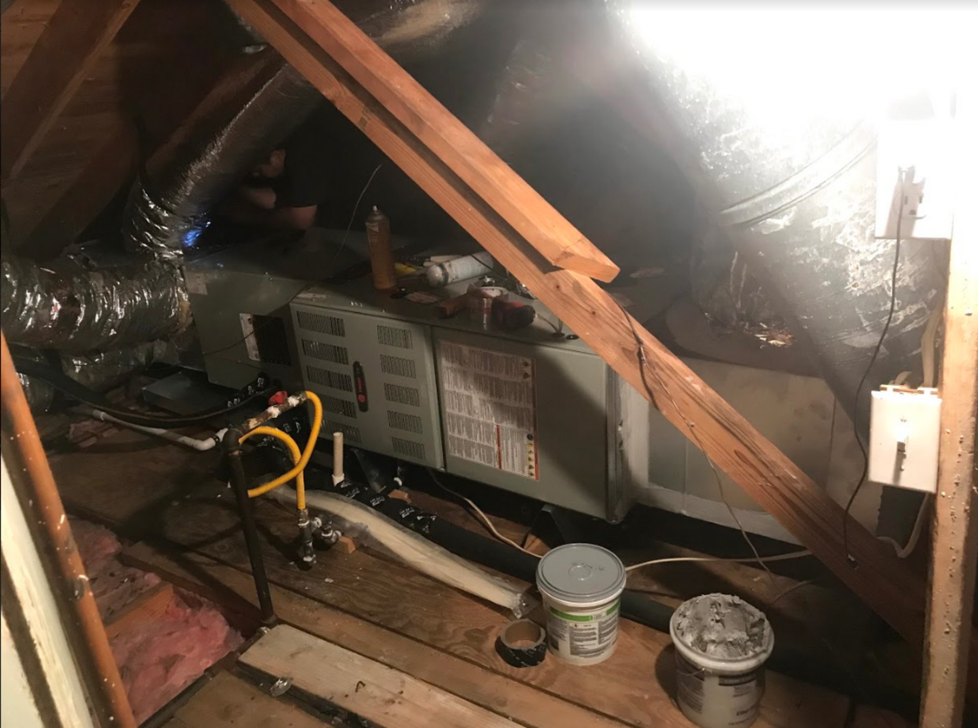 A picture of an attic with a heating and cooling system.