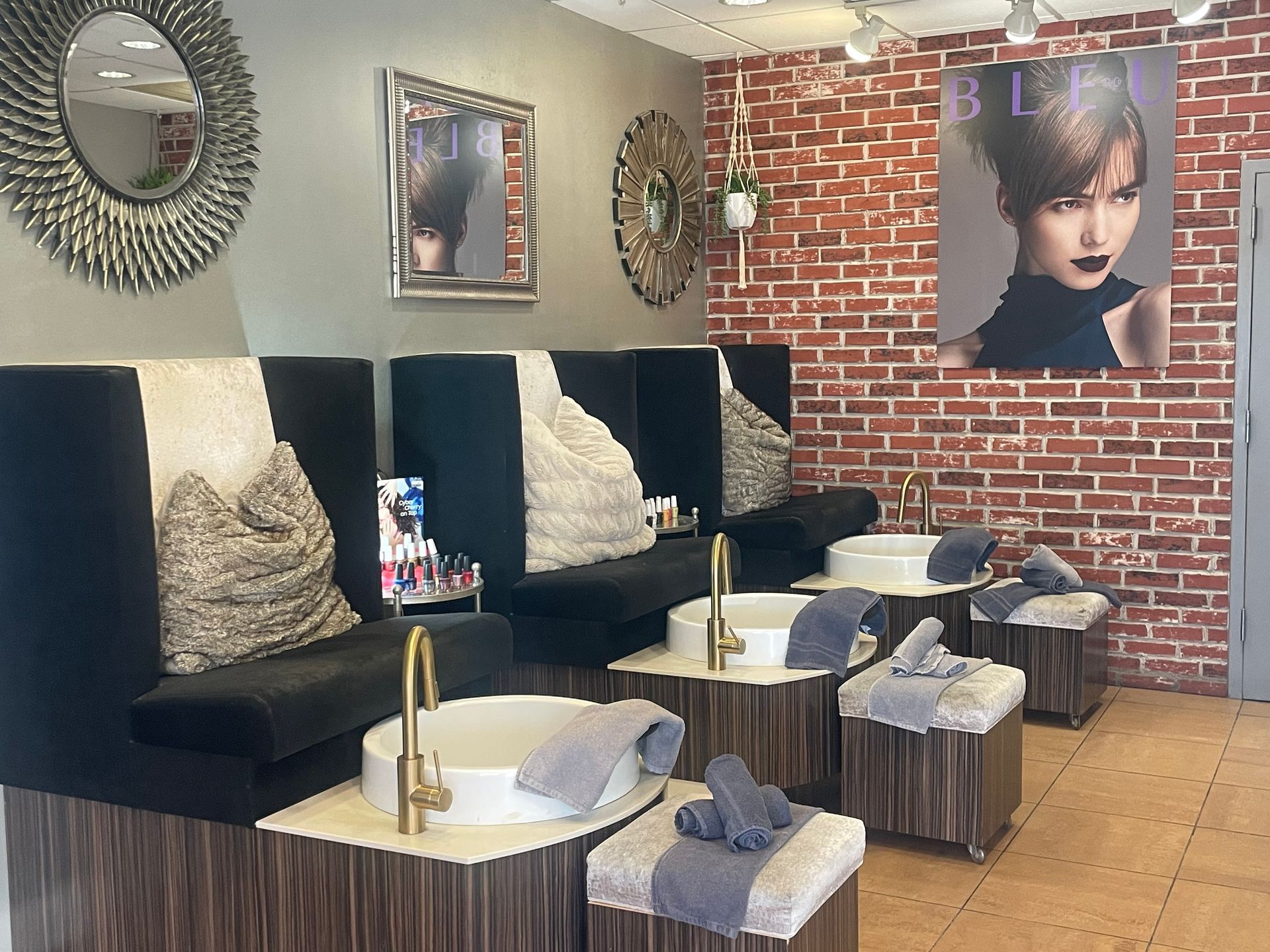 A salon with a brick wall and a picture of a woman on the wall.