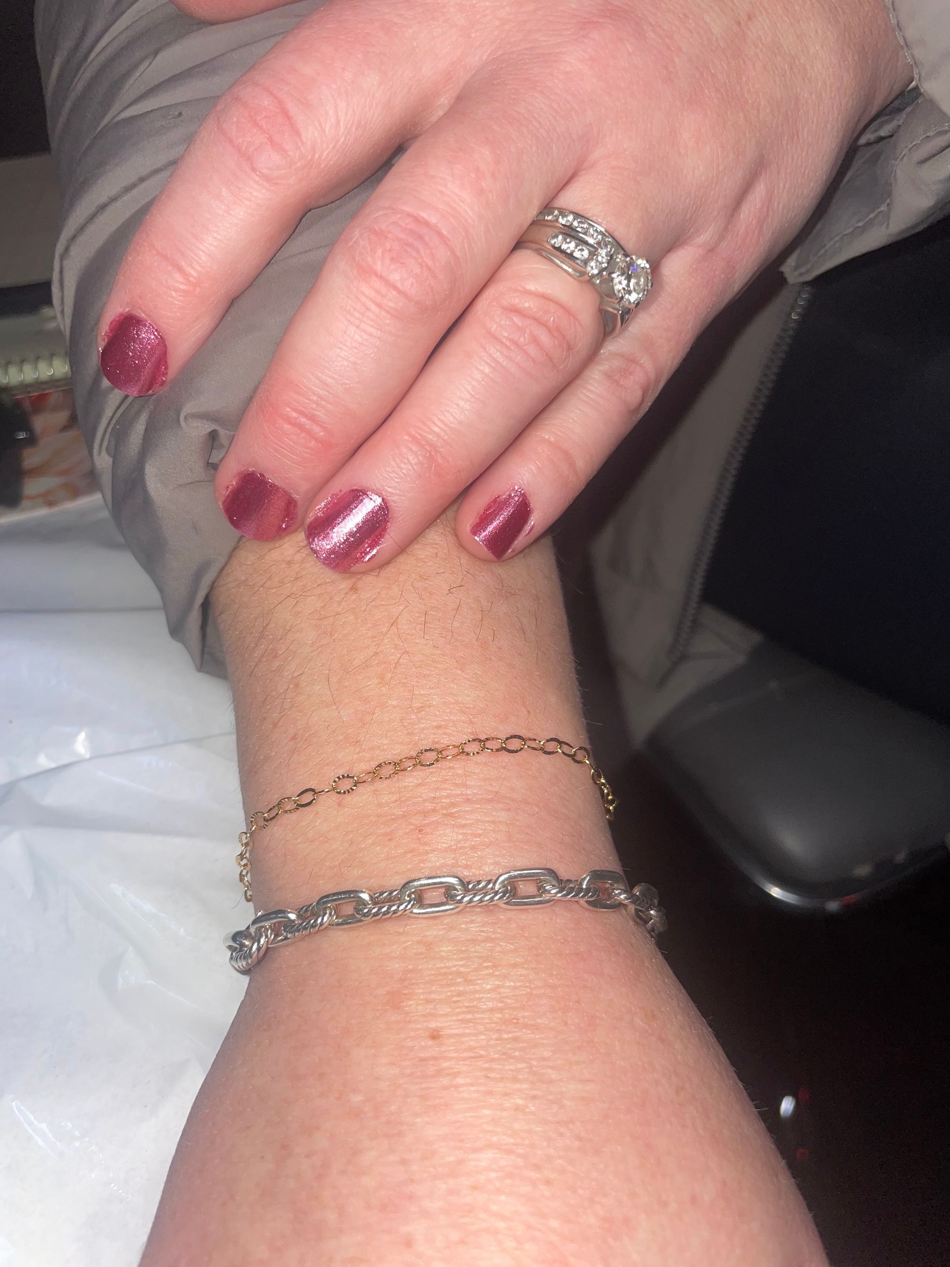 A woman wearing a ring and a bracelet on her wrist