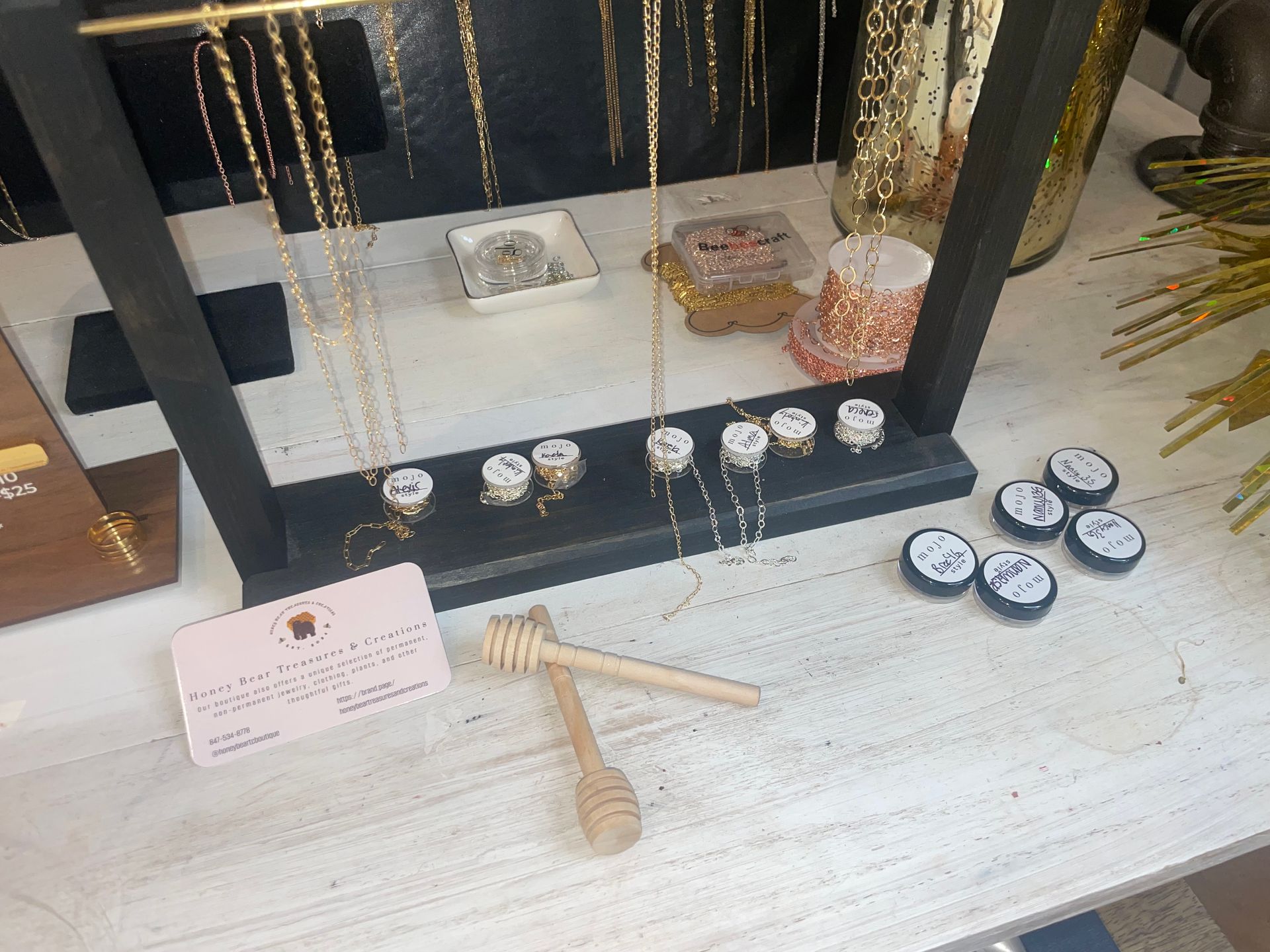 A table with a display of jewelry and a honey dipper