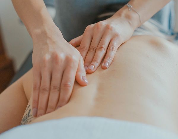 A woman is getting a massage on her back at a spa.