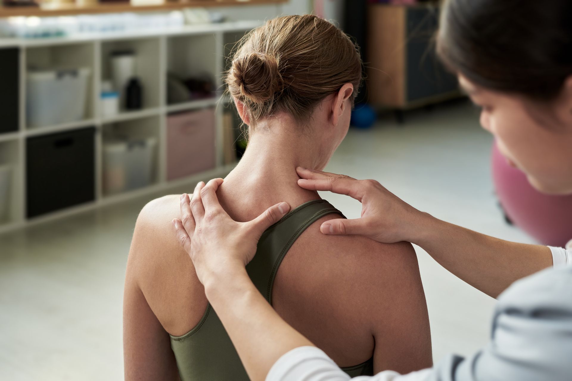 A woman is getting a massage on her neck and shoulder.