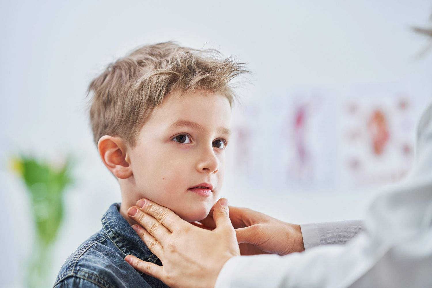 A healthcare provider examining a child's neck during a medical check-up.