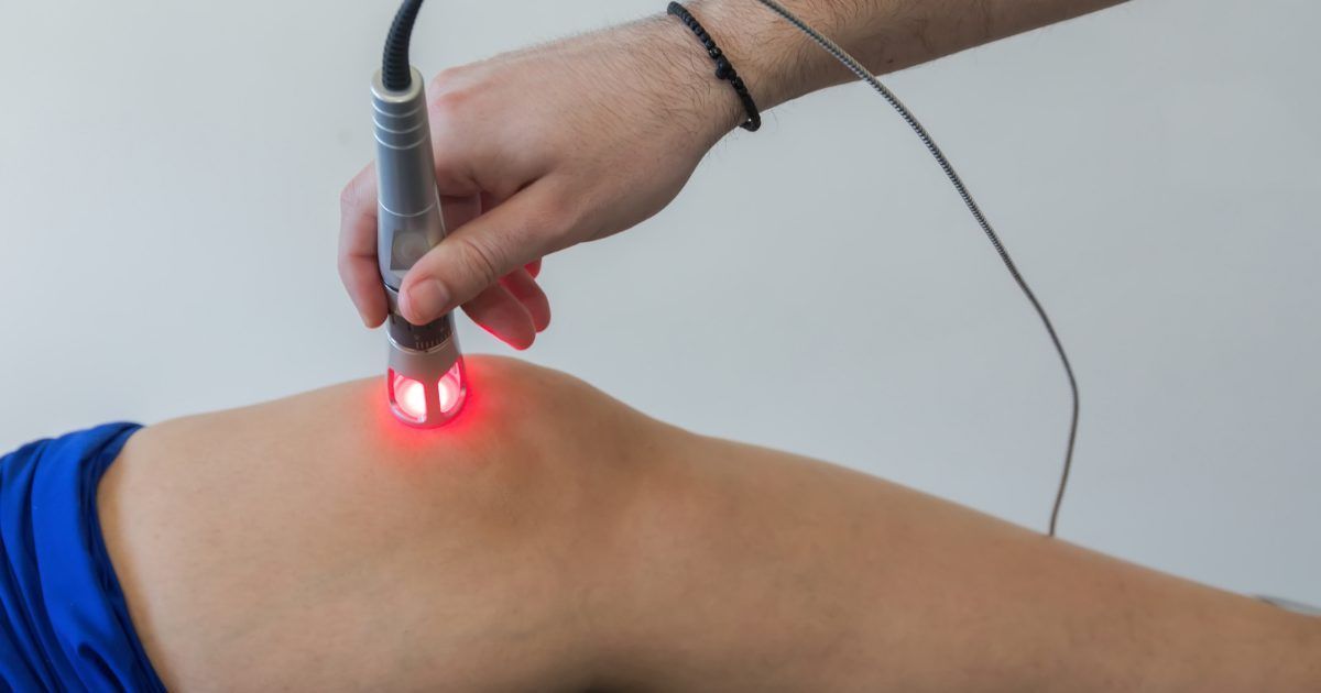 a person is getting a laser treatment on their knee .