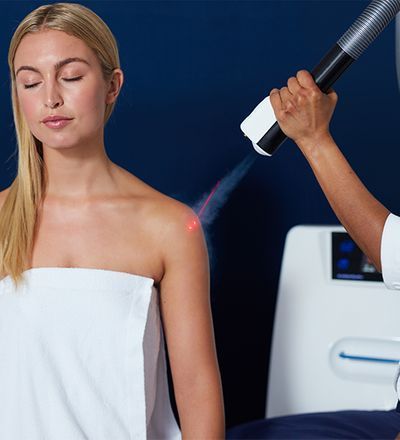 a woman is getting a laser treatment on her shoulder