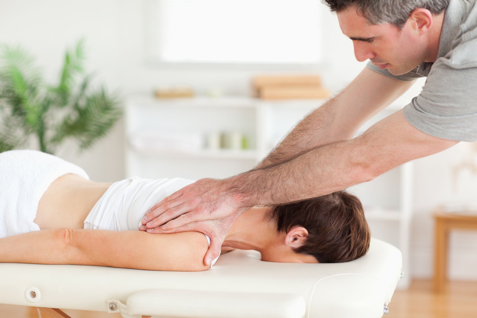 A man is giving a woman a massage on a table.