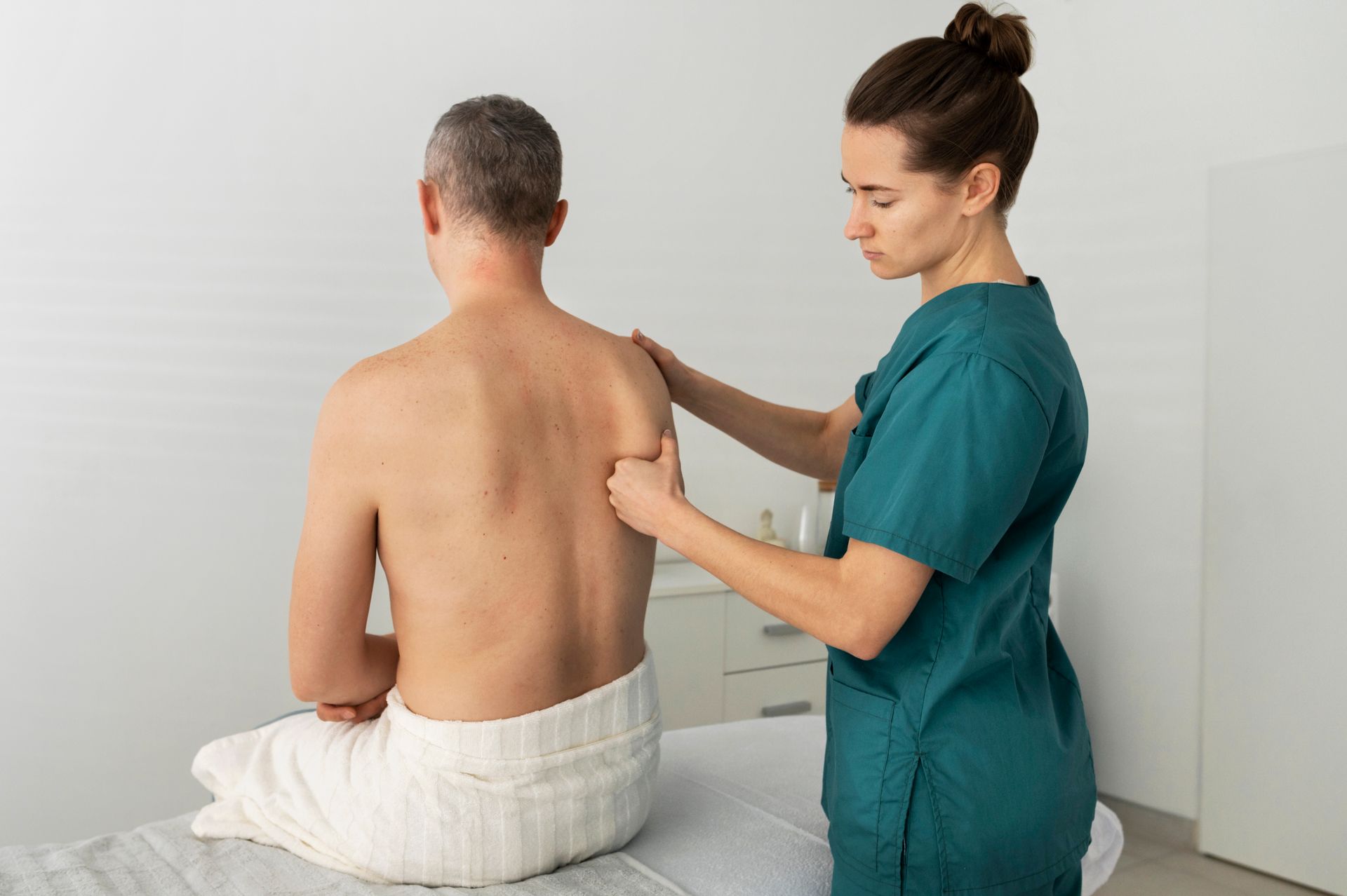 a woman is giving a man a massage on his back .