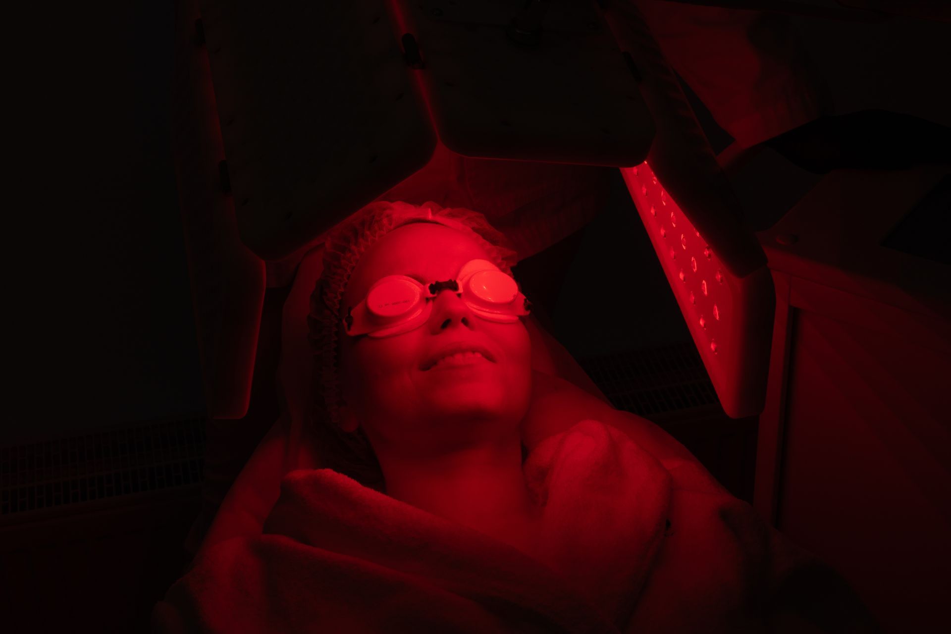 Person wearing eye protection inside a red light therapy machine.