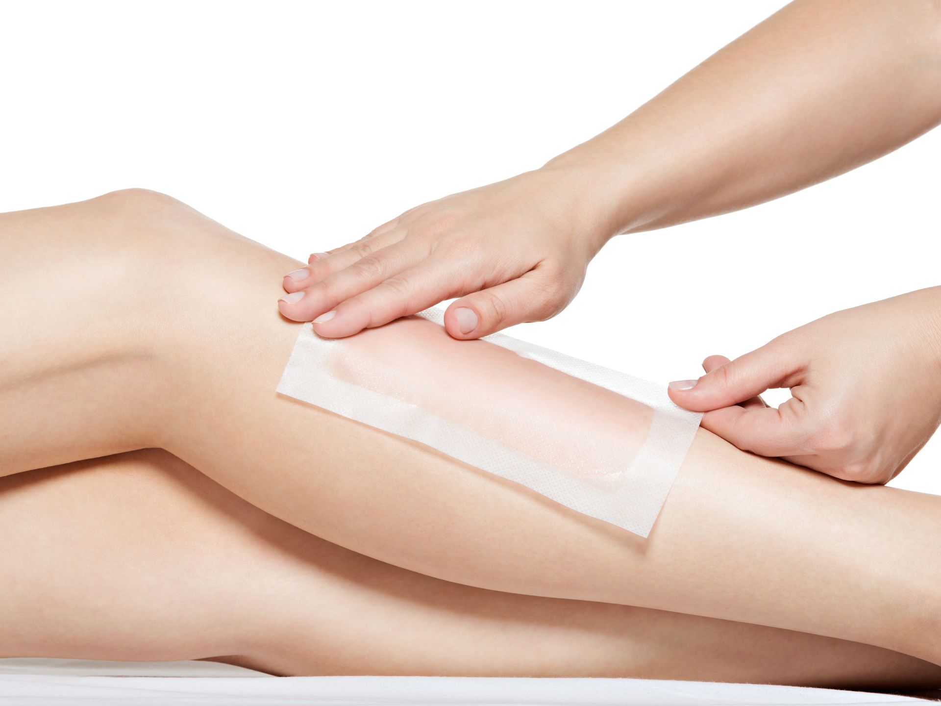 a woman is getting her legs waxed with wax strips .