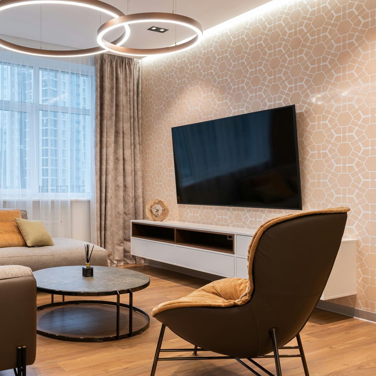 A living room with a couch , chair , table and television.