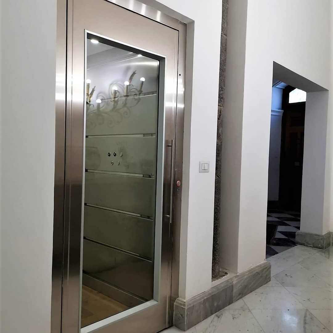 Un corridoio con una porta in acciaio inox e una porta in vetro