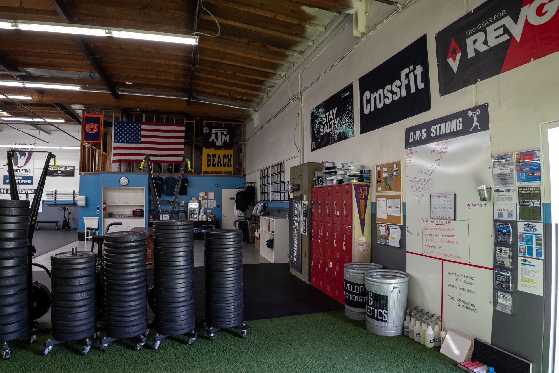 A gym with a lot of weights and a sign that says crossfit