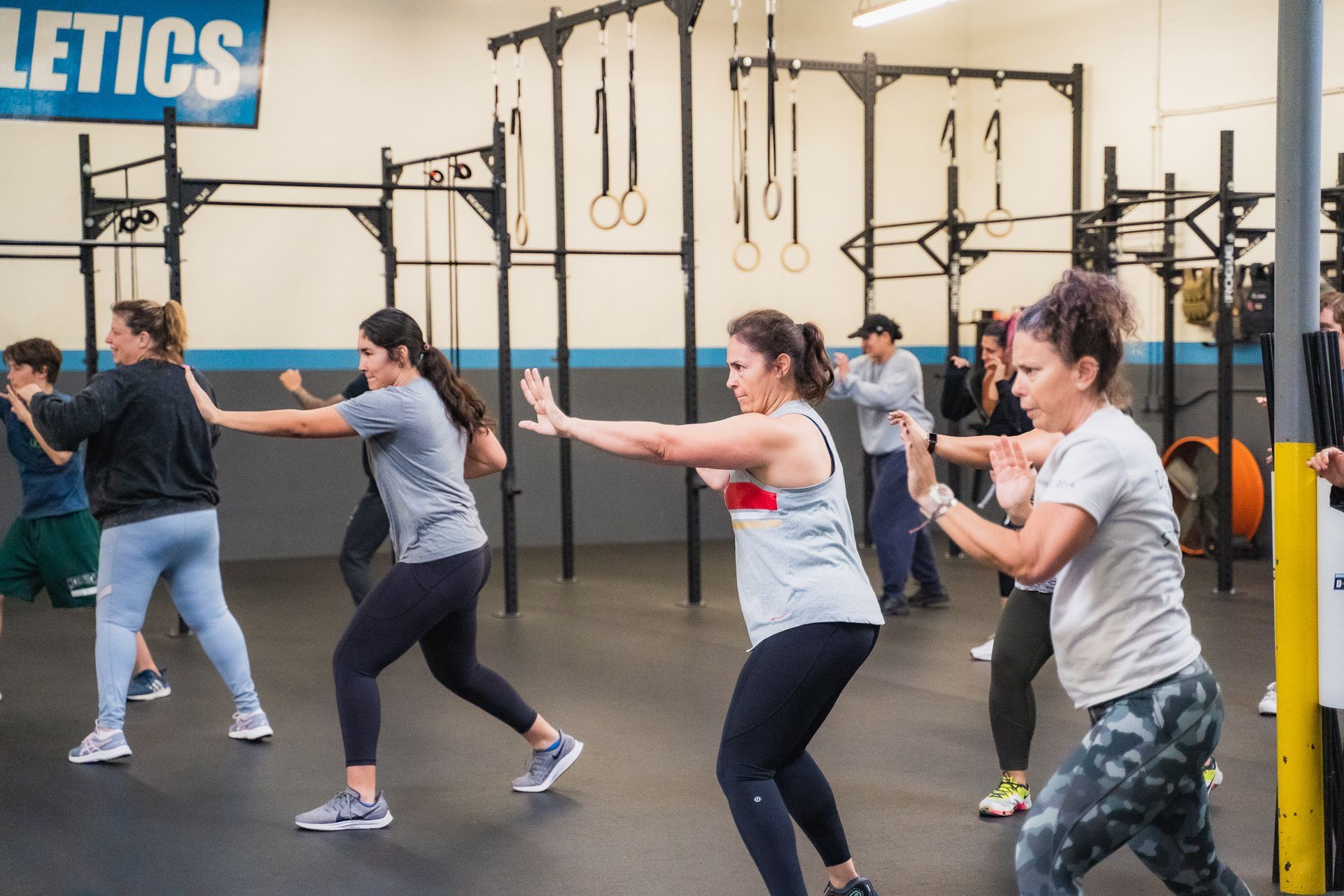 A group of women are doing squats in a gym.