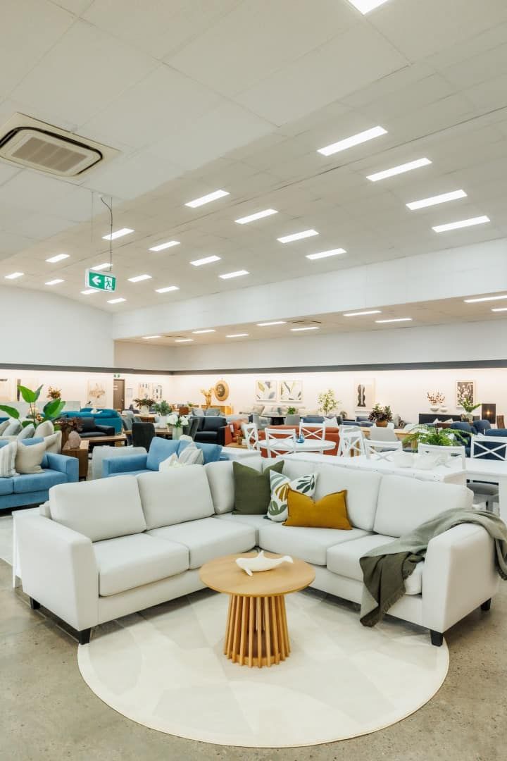 A Living Room With a White Sectional Couch and a Wooden Table — The Comfort Zone Darwin In Winnellie, NT