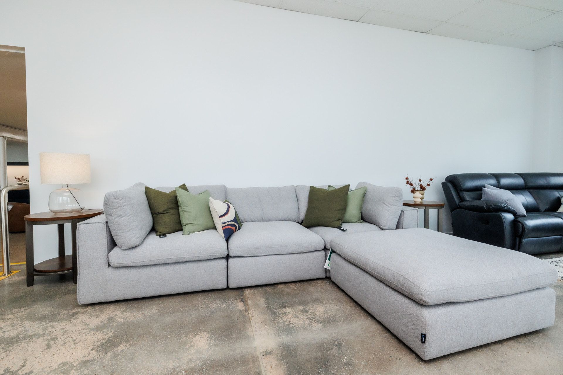 A Living Room With a Large Sectional Couch and Ottoman — The Comfort Zone Darwin In Winnellie, NT