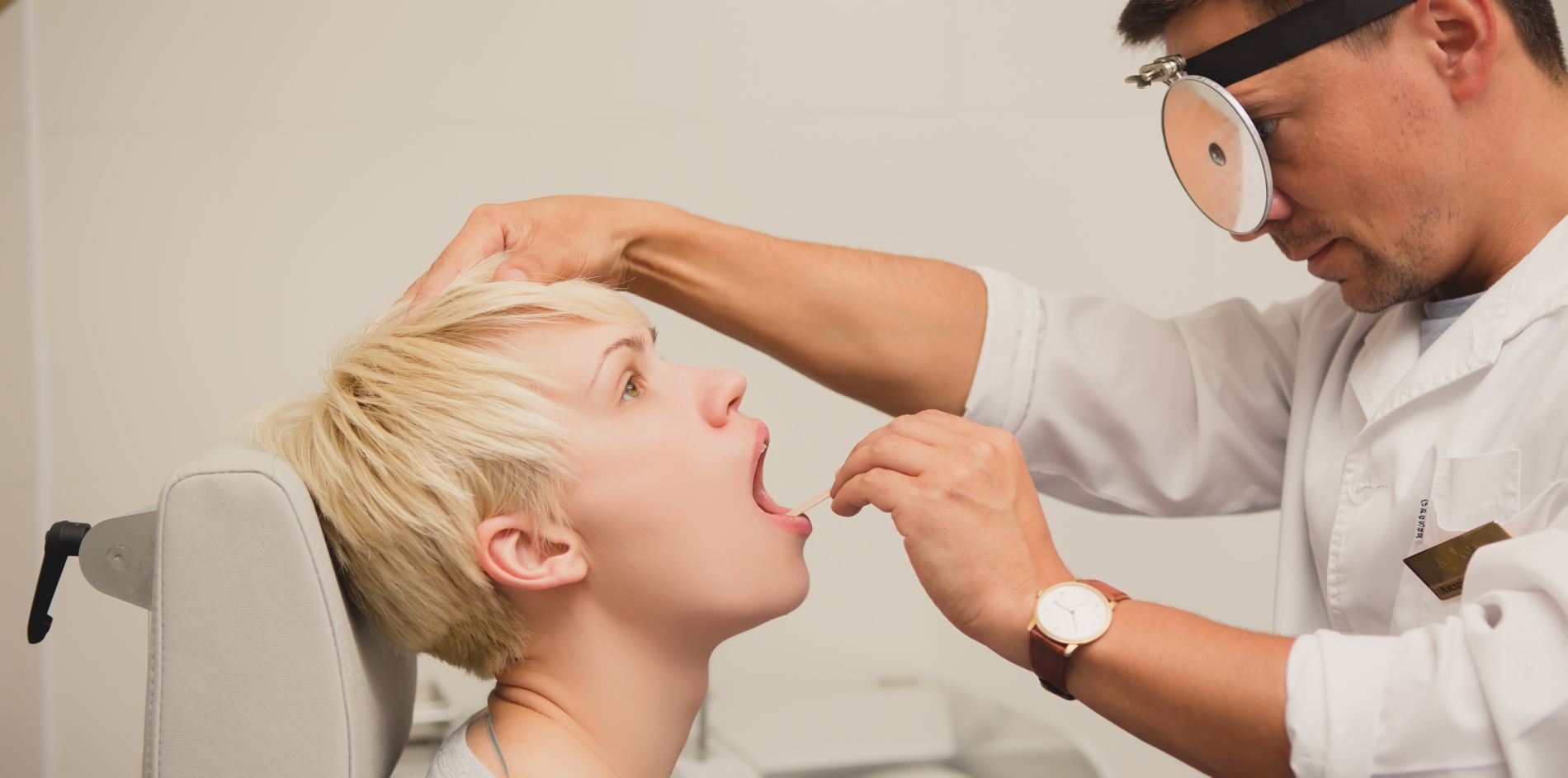 A doctor examining a patient's throat
