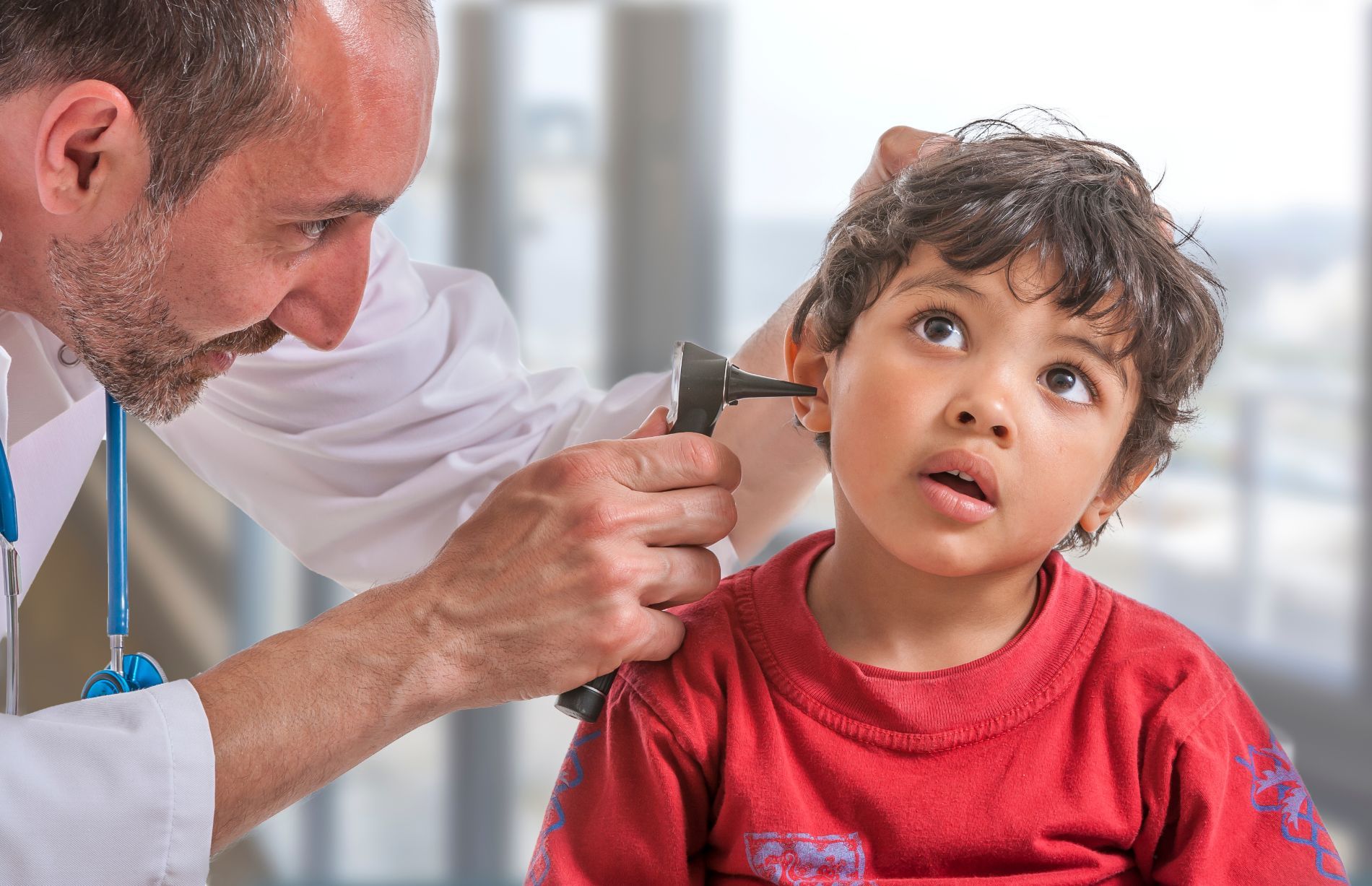 A doctor looking in a child's ear canal
