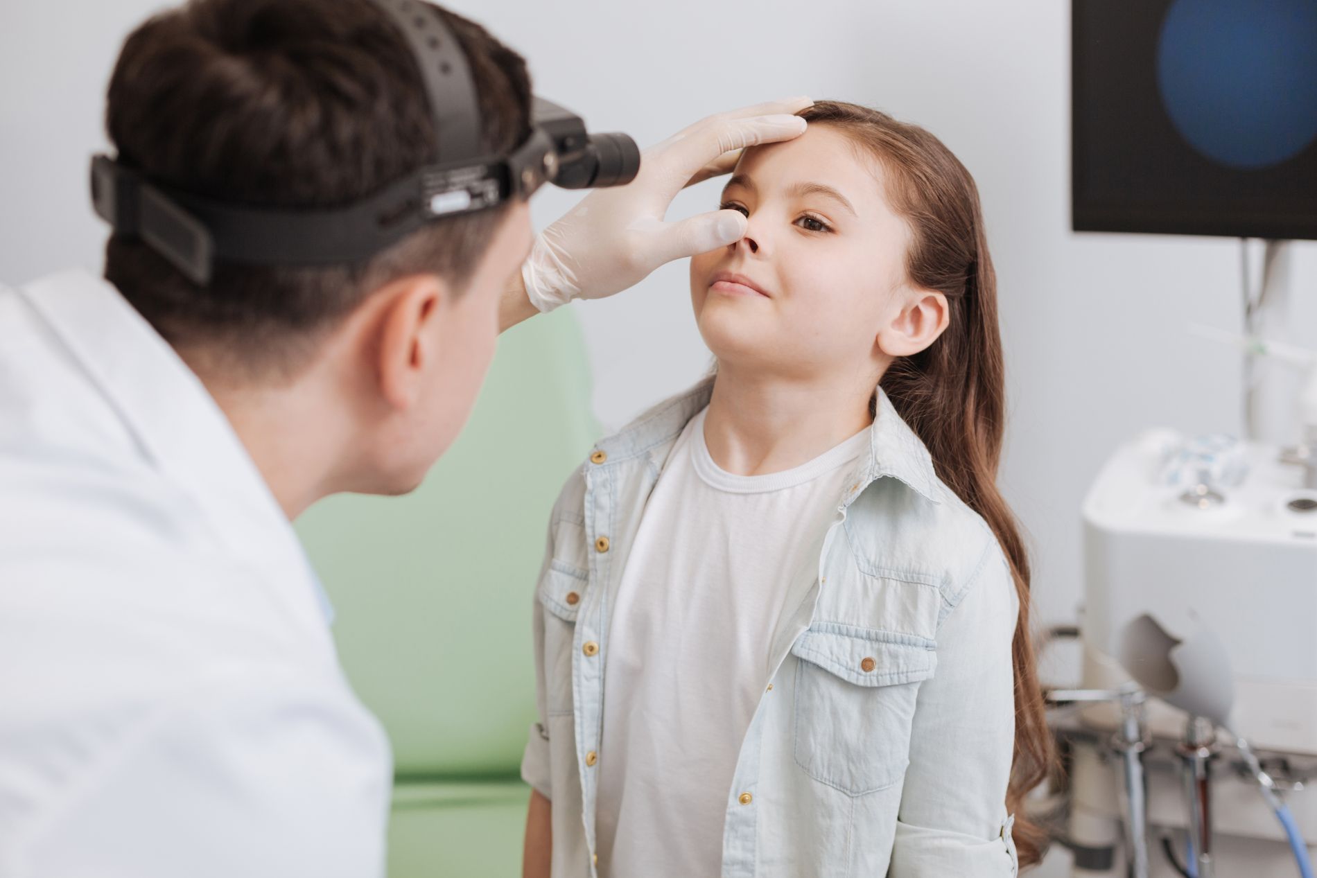 Doctor looking into a child's nose