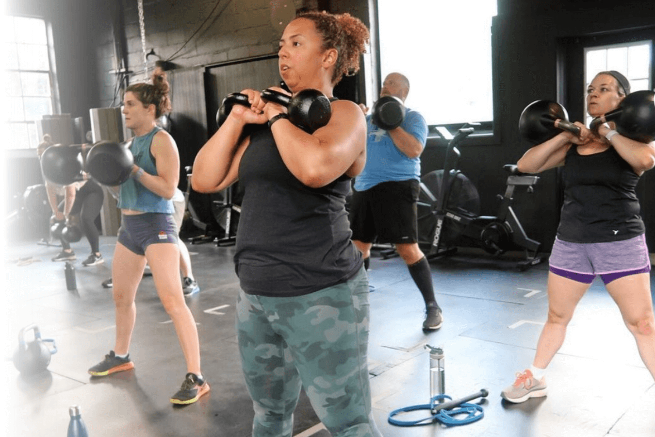 A group of people are doing exercises with kettlebells at SOMA MVMT