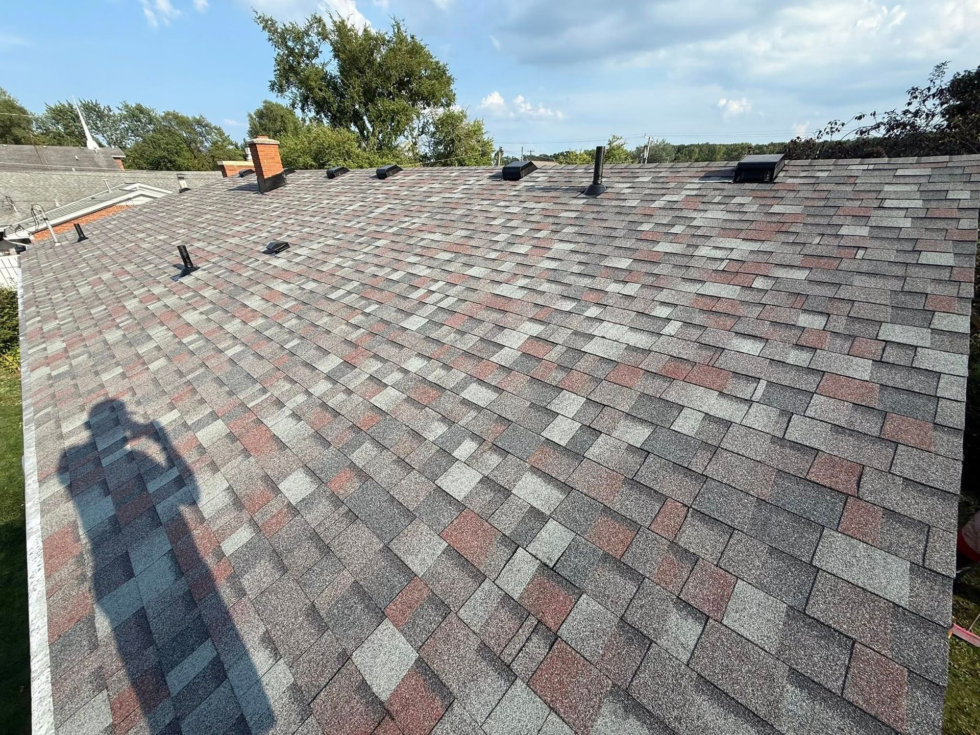 Multicolor asphalt shingle roof on a sunny day.