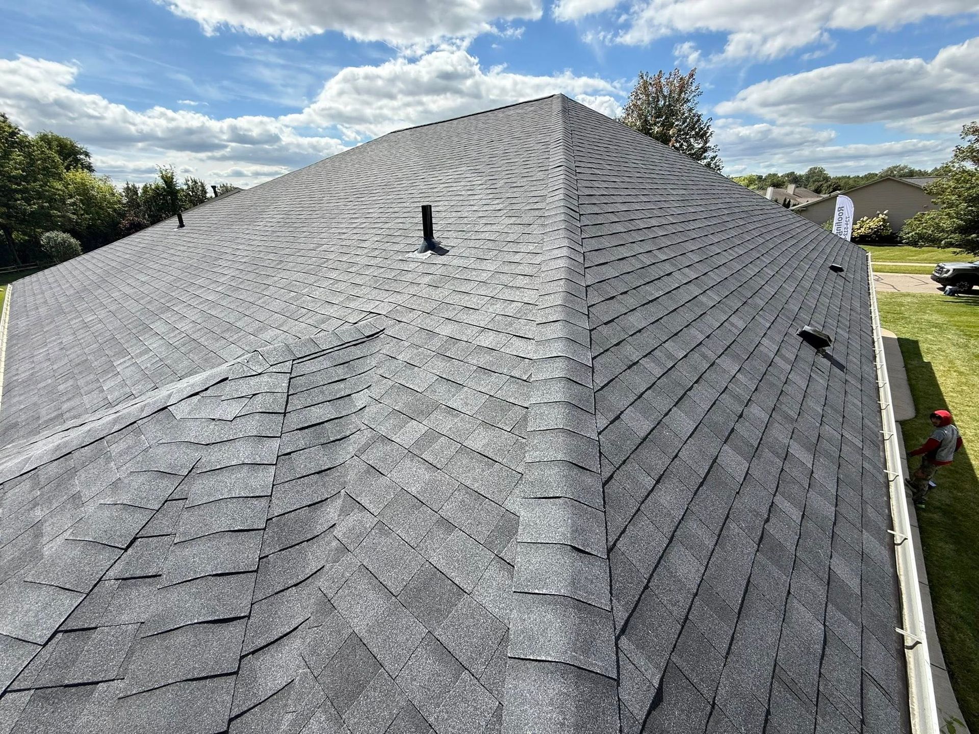 Dark gray asphalt shingle roof on a sunny day.