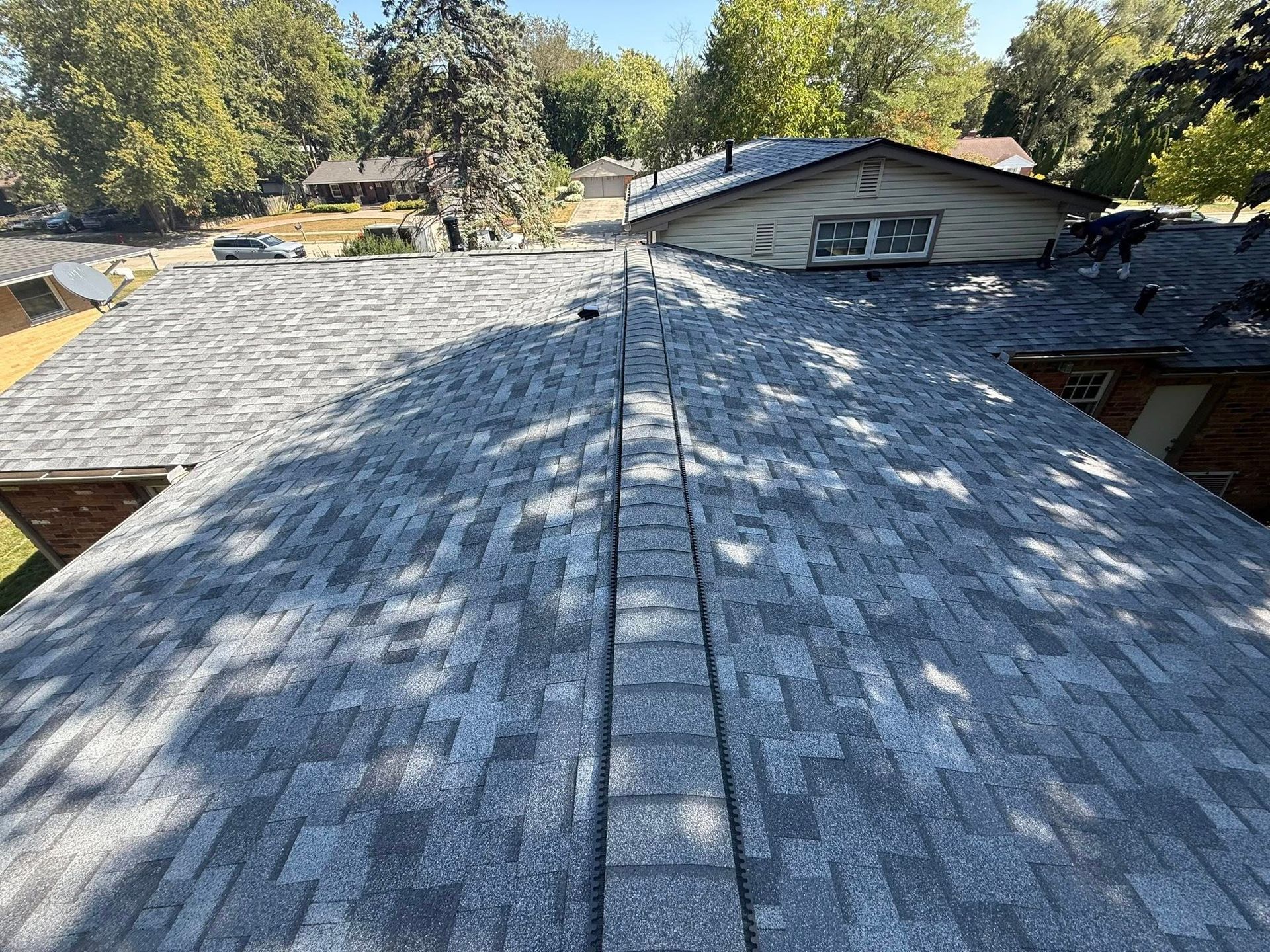 Gray asphalt shingle roof on a house, view from above.