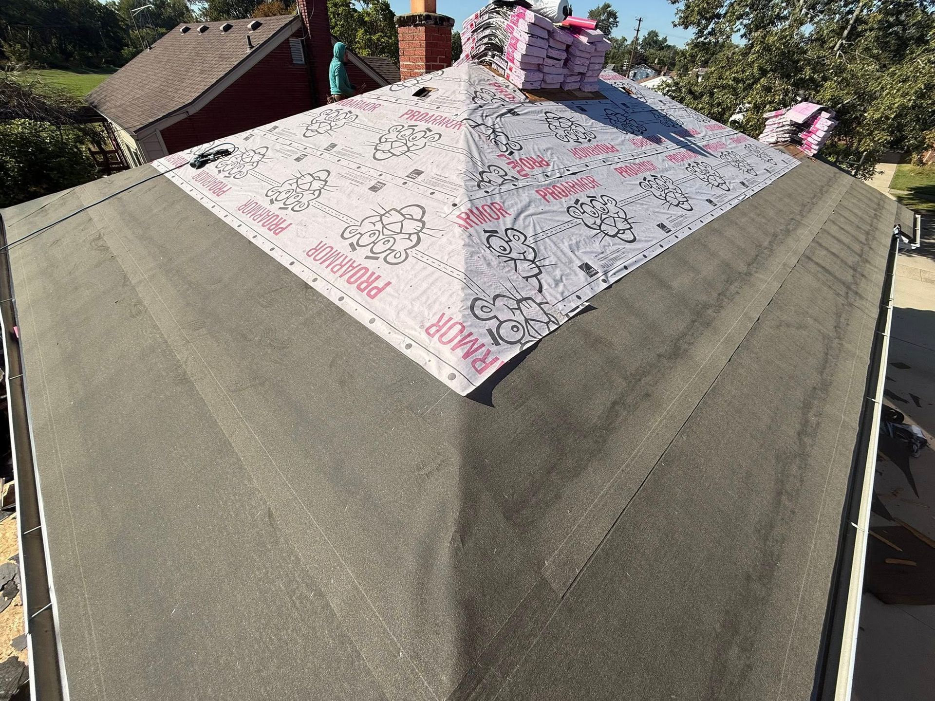 Partially completed roof with new underlayment on top.