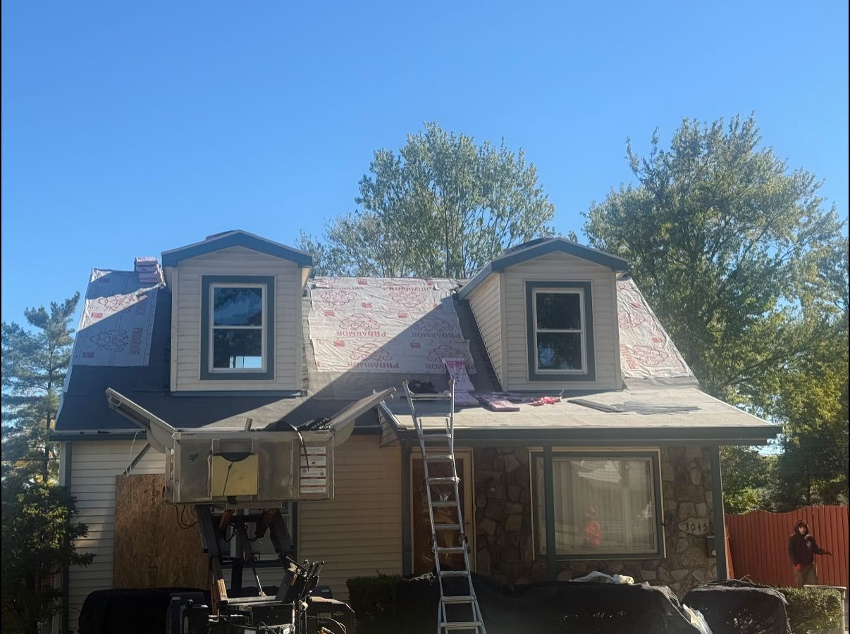 House with roof partially torn off, ladder, and basketball hoop, under a blue sky.