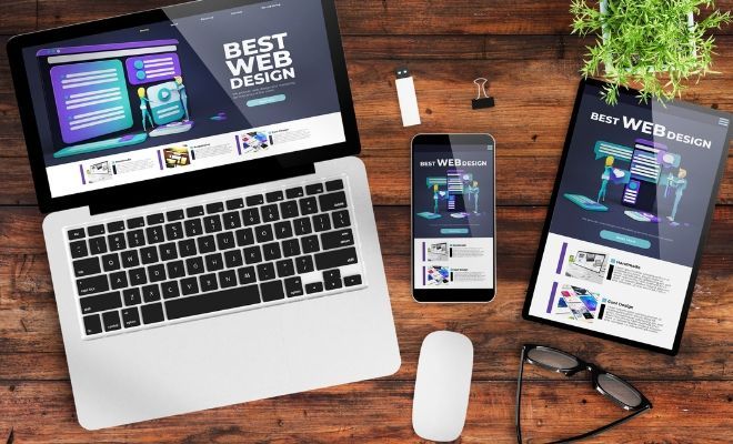 A laptop , tablet , phone and mouse are on a wooden table.