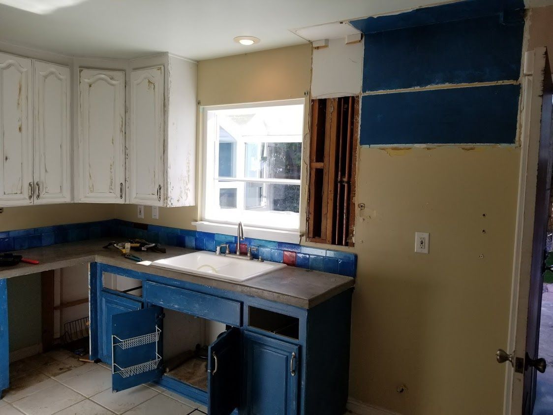 A kitchen with blue cabinets and white cabinets is being remodeled.