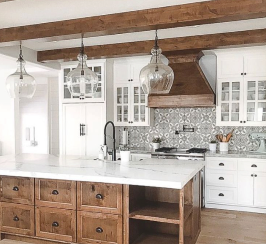 A kitchen with white cabinets and wooden drawers