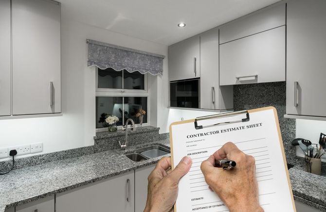 A person is writing on a clipboard in a kitchen.