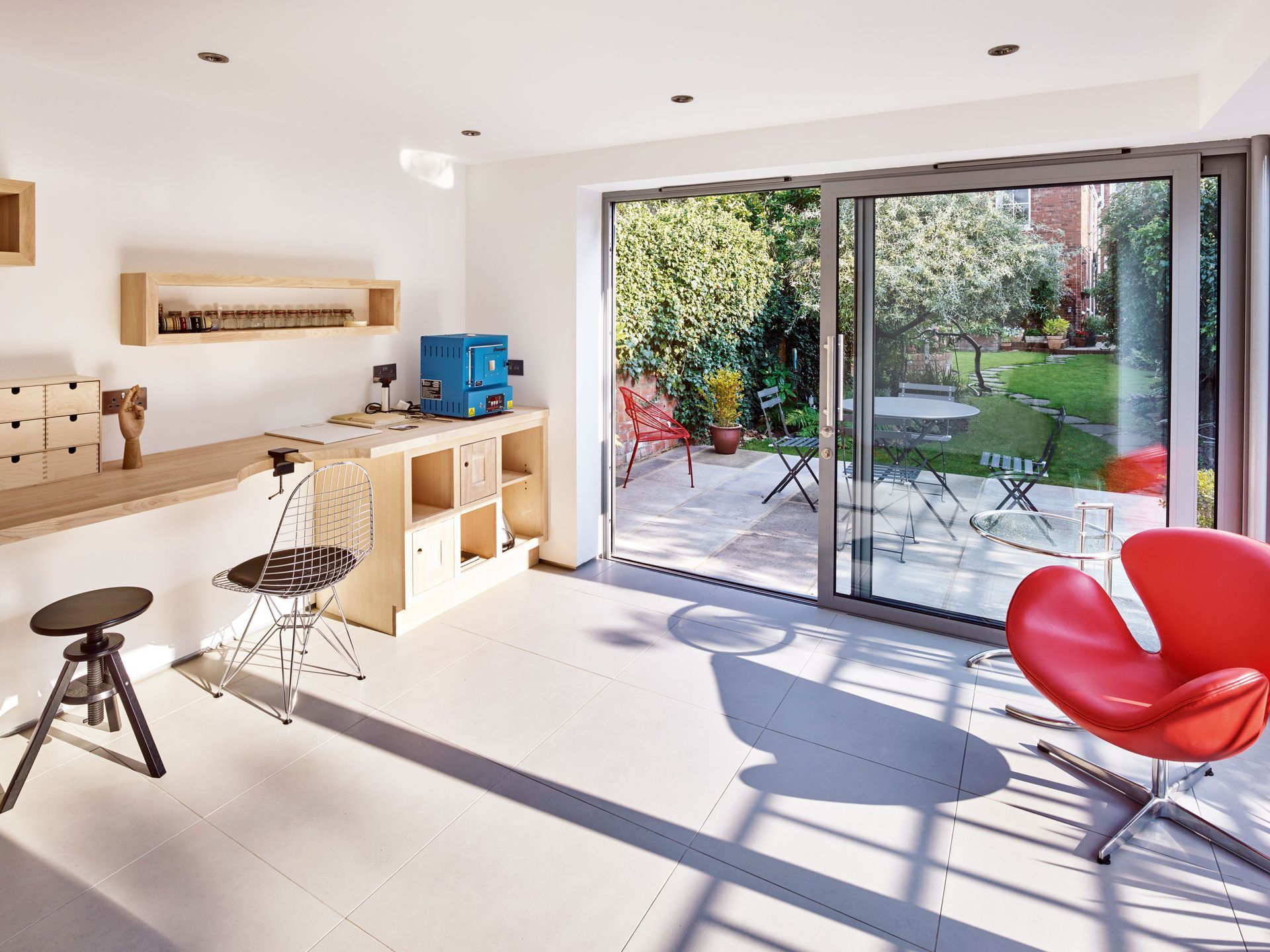 A living room with a red chair and a sliding glass door