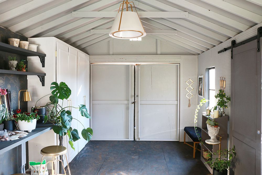 A room with a lot of potted plants and a sliding barn door.