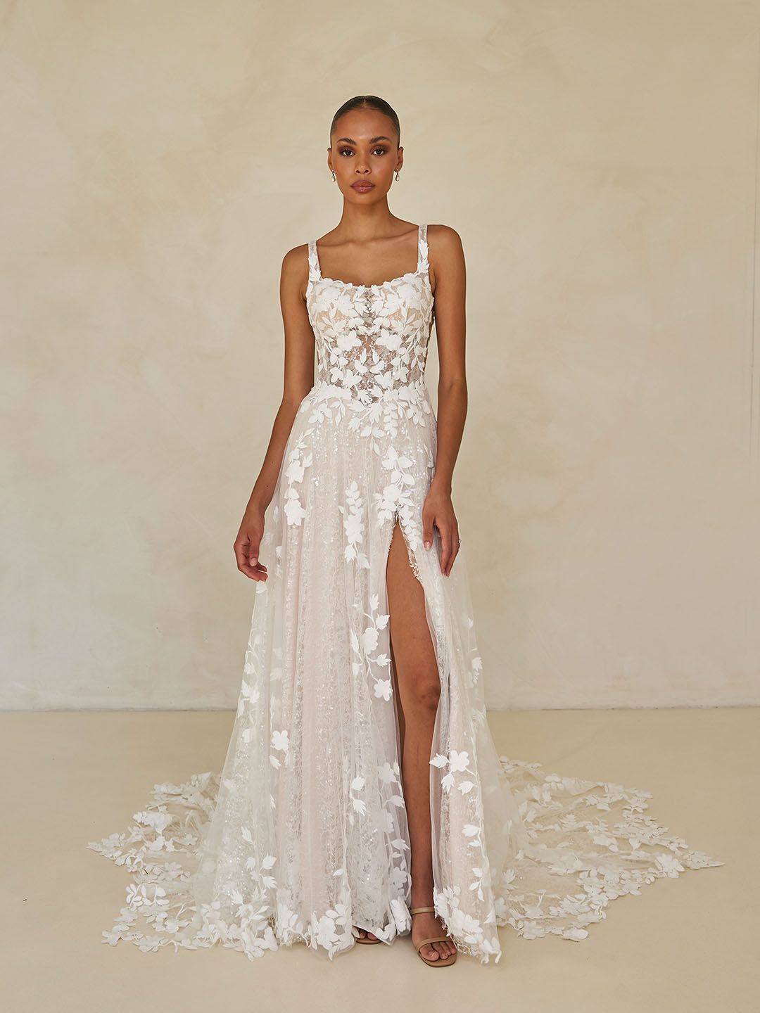 Laiya van Madi Lane heeft een A-lijn silhouet met een laag glitter tule om een ​​extra glans toe te voegen aan haar all-over pailletten kantpatroon. Haar lijfje is ontworpen met een moderne, trendy piek-stijl halslijn met een sexy maar ingetogen illusie plunge. 