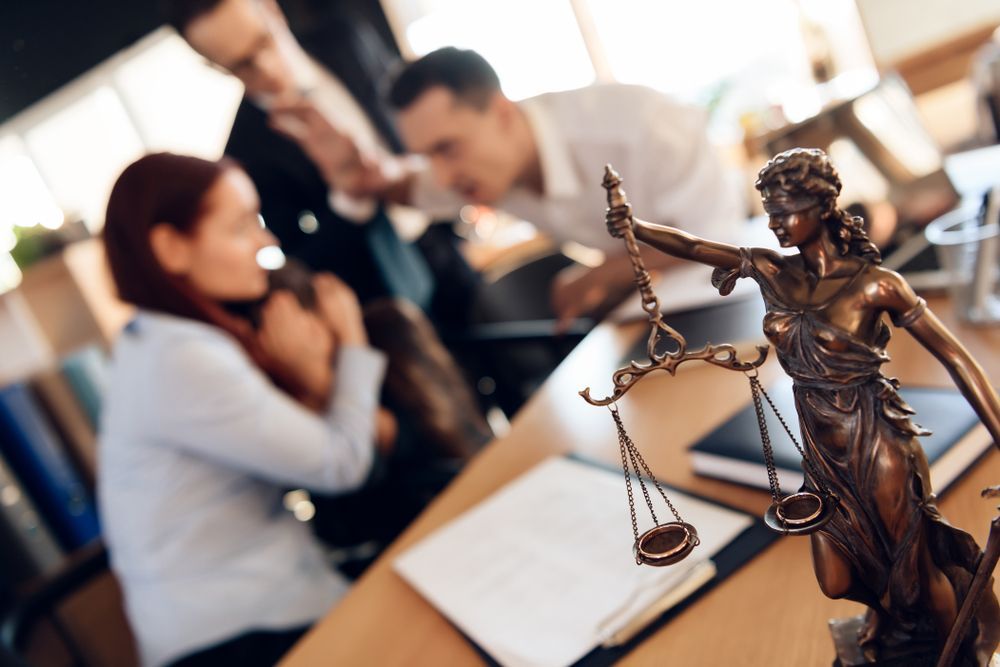 a statue of lady justice is sitting on a desk in front of a group of people