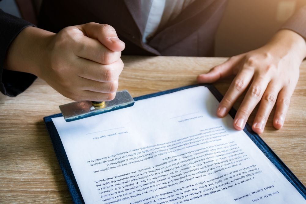 a person is stamping a document on a clipboard