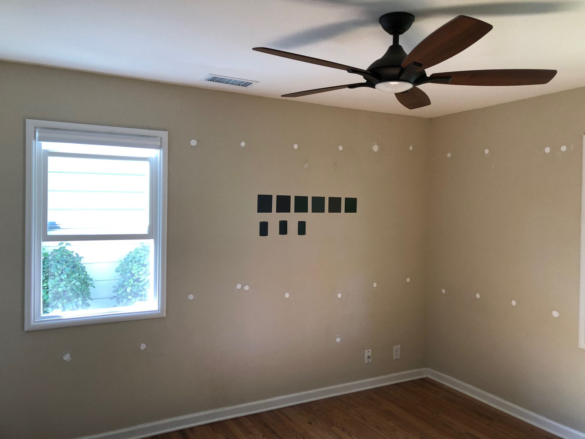 An empty room with a ceiling fan and a window