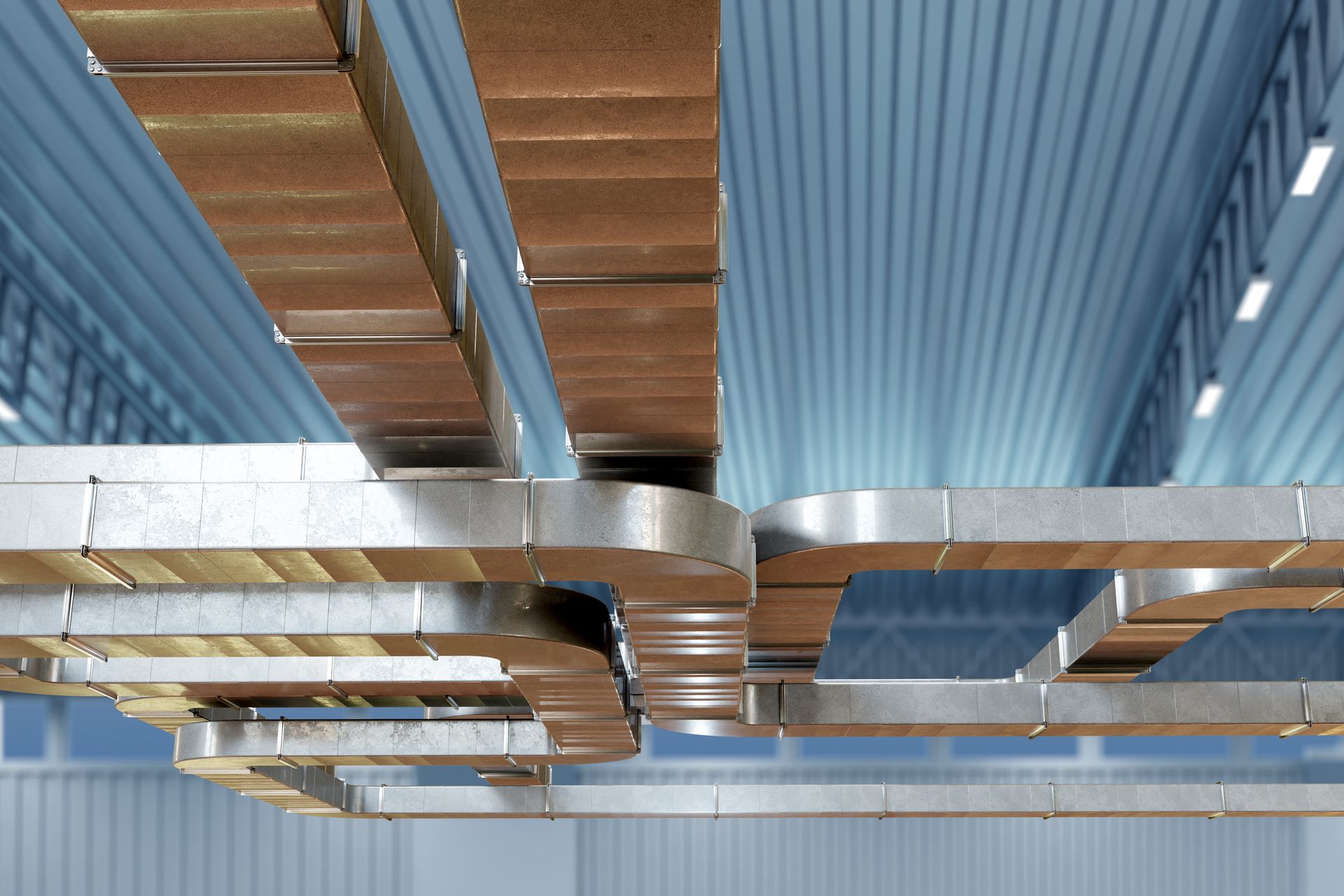 Silver and copper HVAC ducts running along a blue, industrial ceiling.
