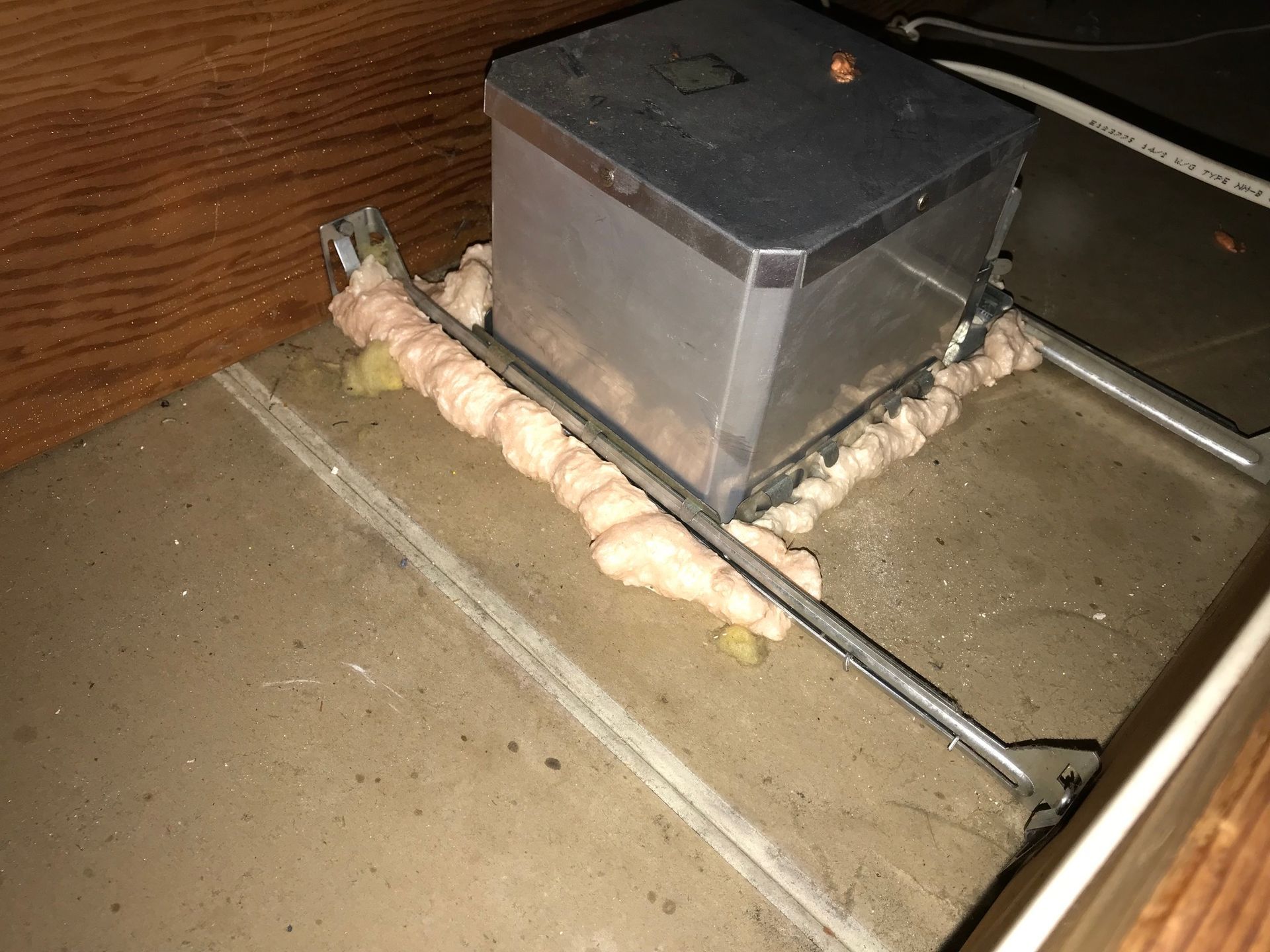 A box with foam on it is sitting on top of a wooden floor.