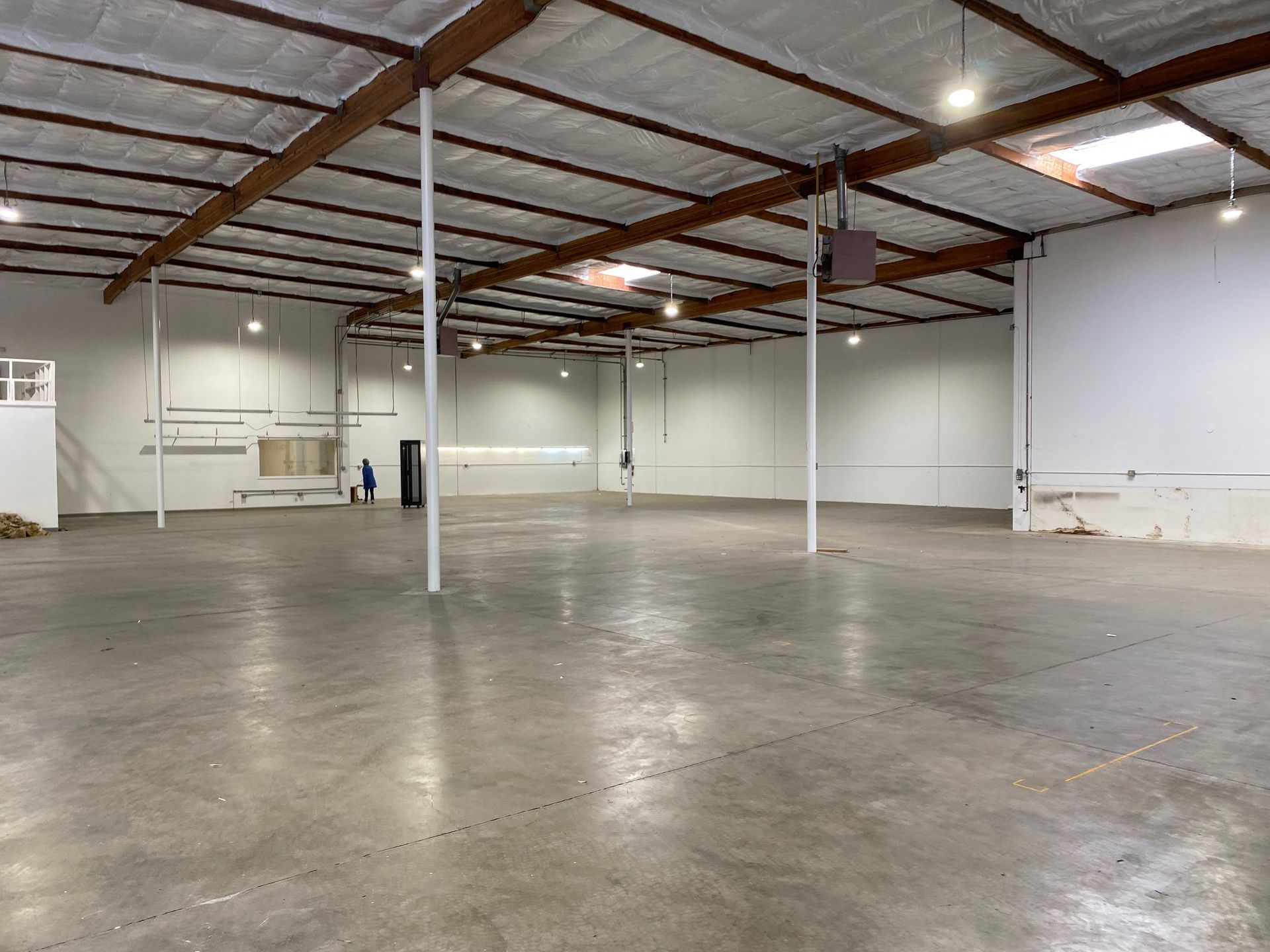 A large empty warehouse with a concrete floor and ceiling.