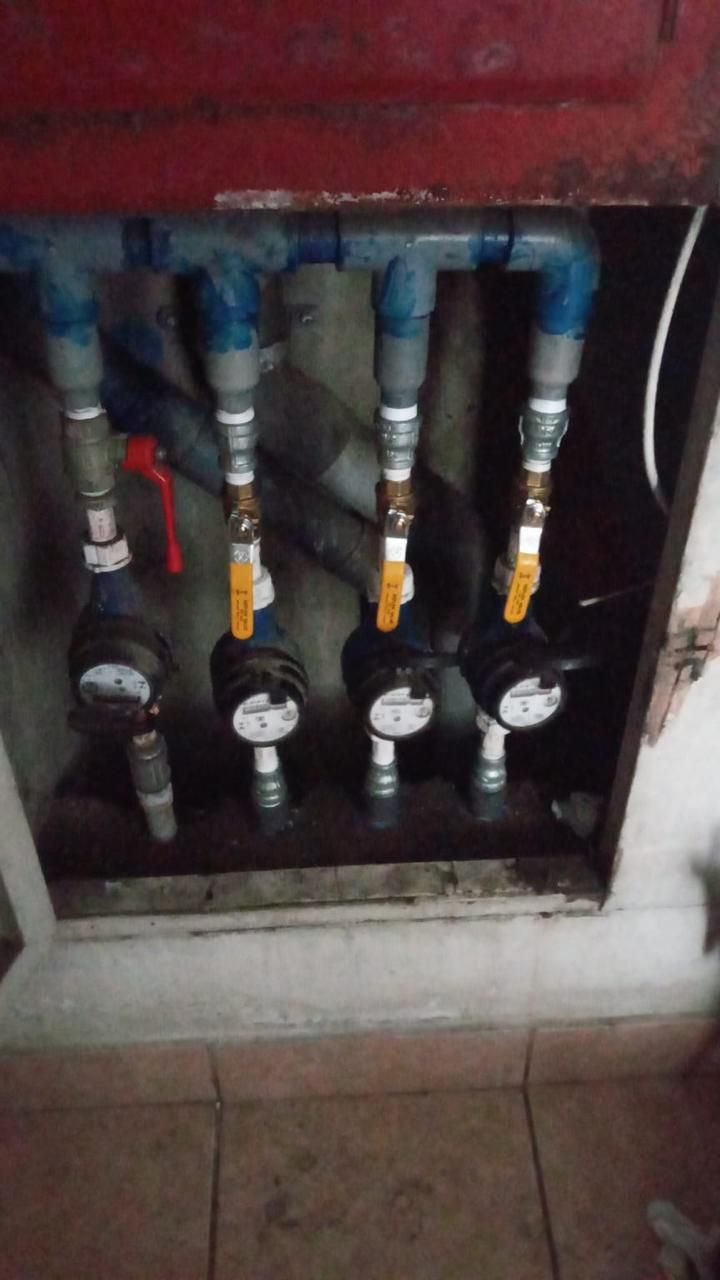 Contadores de agua dentro de una caja mural. Cuatro contadores con válvulas y tuberías de conexión.