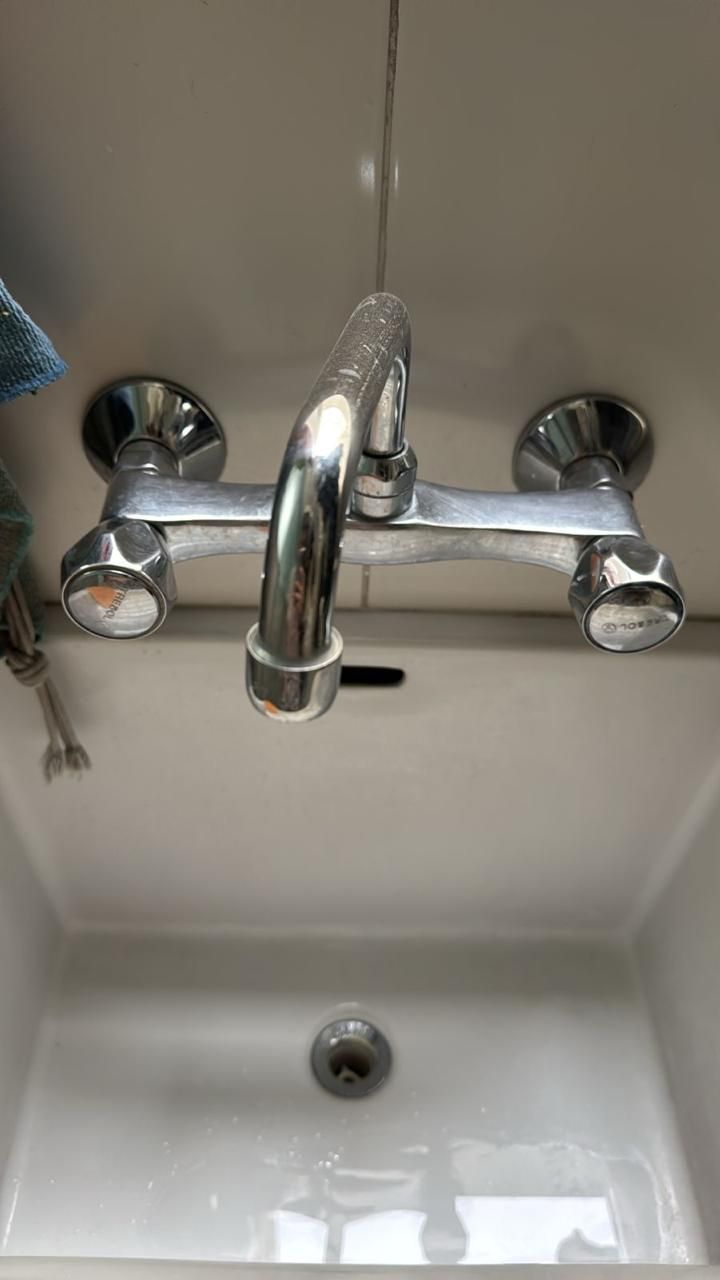 Grifo plateado sobre un lavabo blanco.