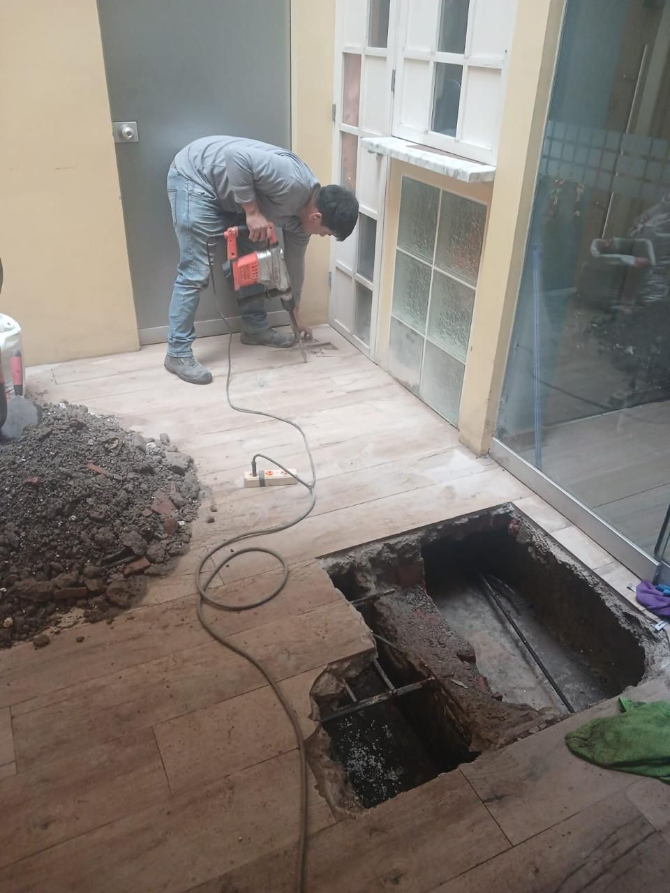 Hombre usando un martillo neumático sobre un suelo de baldosas