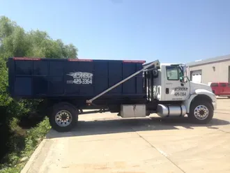 A dump truck is parked on the side of the road.