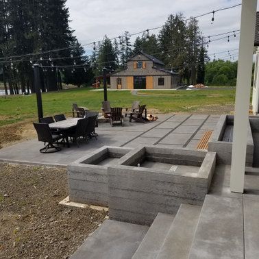 A patio with a table and chairs in front of a house.