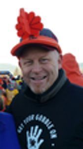 A man wearing an orange hat and a black shirt with a hand on it