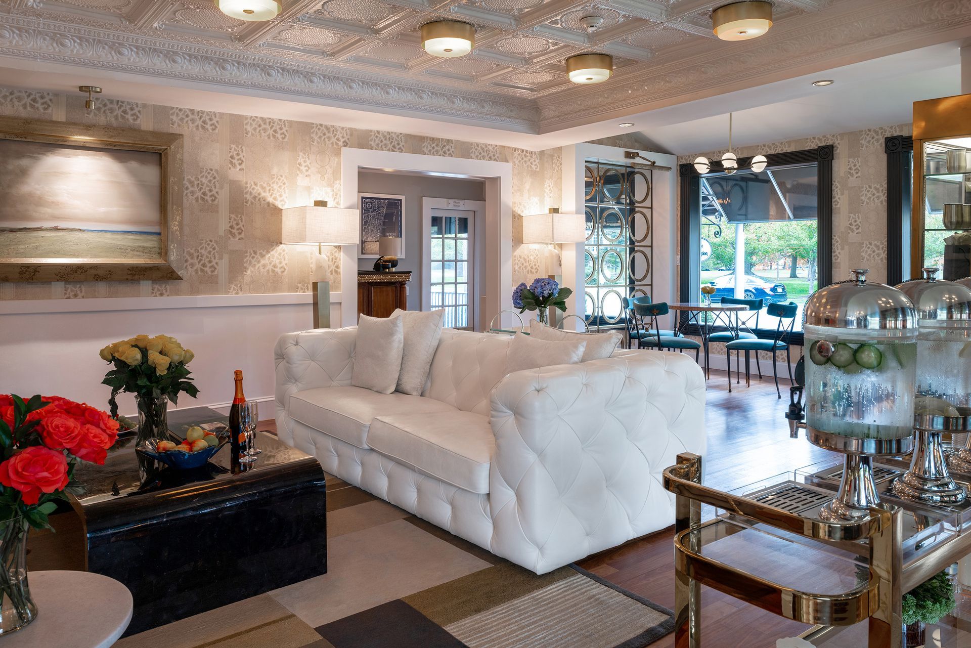 A living room with a white couch and a bar cart